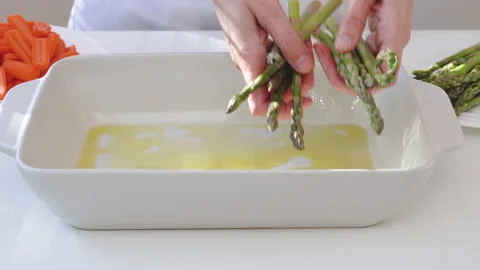 White ceramic baking dish, and fresh vegetables, carrot, green beans, asparagus Stock Footage 166113179