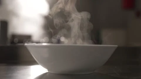 White ceramic bowl filled with hot food emitting steam Stock Footage 336623622