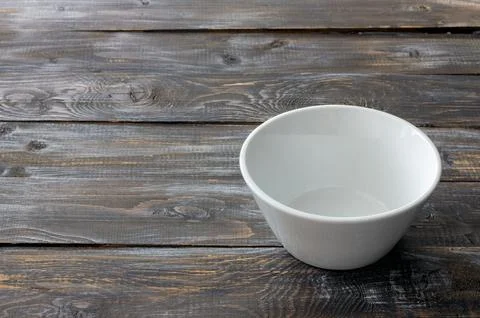White ceramic bowl on rustic dark wooden table, top view with copy space fo.. Stock Photos