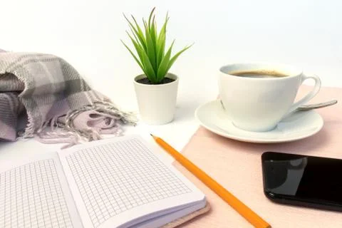 White ceramic cup of coffee, notebook, pencil, green plant and smartphone on  Stock Photos