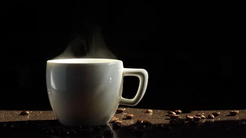 White ceramic cup of coffee stands on the kitchen table and steam comes from it. 스톡 동영상 113448717