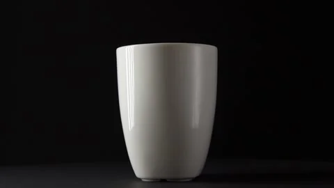 White ceramic Cup on a dark background turns the handle Video stock 131049985