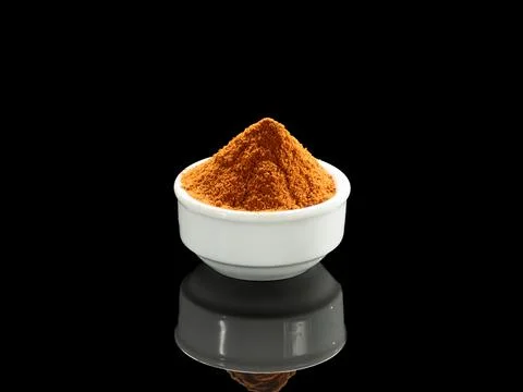 A white ceramic cup filled with red Mexican taco seasoning stands on a blac.. Foto stock