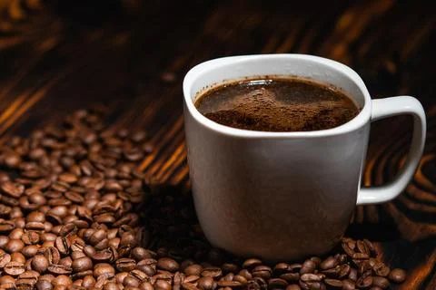 White ceramic cup of hot black coffee with crema on a dark wooden background 스톡 사진
