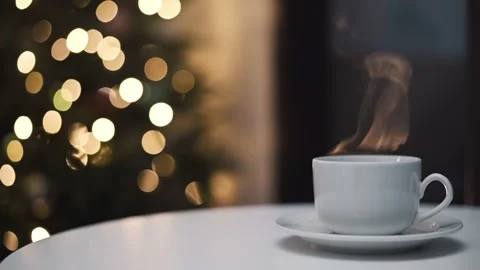 White ceramic cup with hot drink of coffee tea cocoa on saucer stands on table Видео 227734583