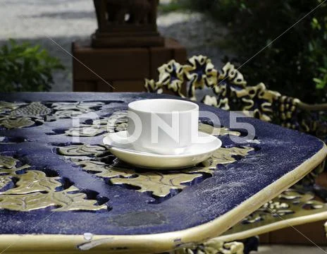 White ceramic cup on saucer above classic table Stock Photos