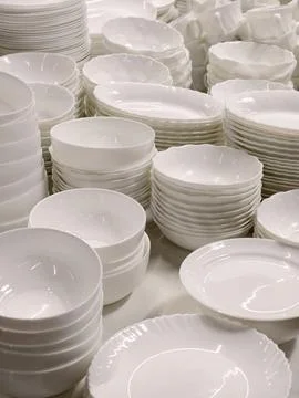 White ceramic cups and plates shown on hypermarket shelves forming a minima.. Stock Photos