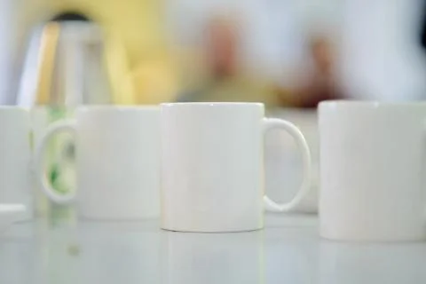 White ceramic cups stand on the table Stock Photos
