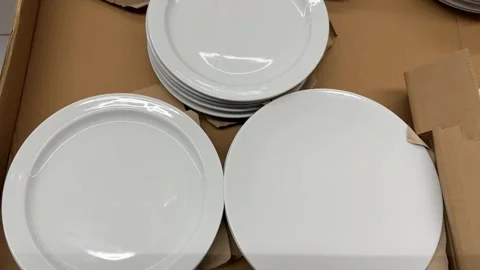 White ceramic dinner plates arranged in cardboard box for kitchenware backg.. Stock Footage 331090455