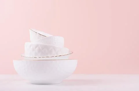White ceramic dishes with thin gold border, different tracery form on white w Stock Photos