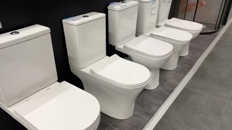White Ceramic Floor Mounted Toilets Display in Plumbing Showroom | Row of Modern Stock Footage 321312726