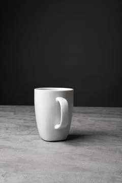 White Ceramic Mug on Grey Table with Dark Background Stock Photos