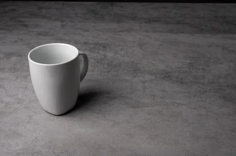 White Ceramic Mug on Grey Table with Dark Background Stock Photos