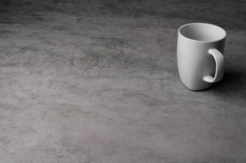White Ceramic Mug on Grey Table with Dark Background Stock Photos