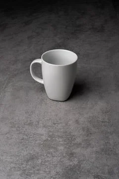 White Ceramic Mug on Grey Table with Dark Background Stock-Fotos