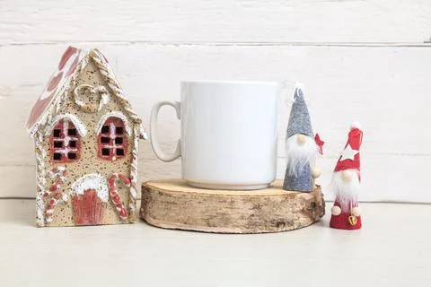White ceramic mug on a light background with a toy house and gnomes Stock Photos