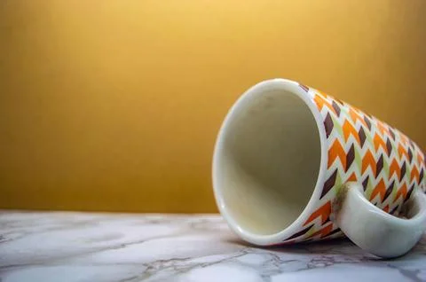 A white ceramic mug with a retro geometric pattern in brown, orange, and li.. Stock Photos