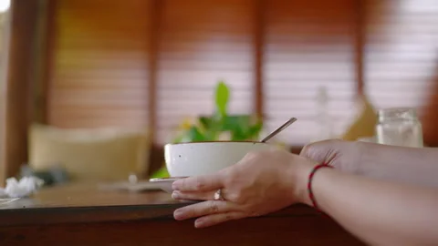 White ceramic plate on table, blurred background. Female hands taking dish in Stock Footage 264846861