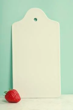 White ceramic serving board and strawberry over light blue backg Stock Photos