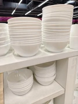 White ceramic tableware including deep plates arranged in stacks on superma.. Foto stock