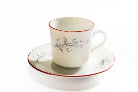 White ceramic tea cup and saucer with red trim and floral pink flowers Stock Photos