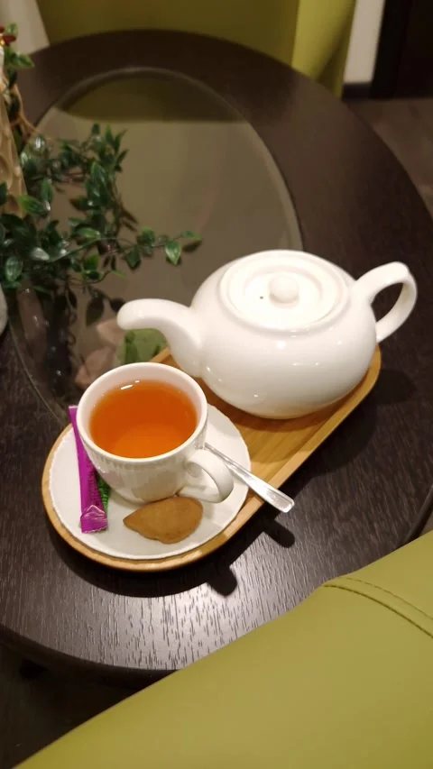 White Ceramic Teapot and Cup of Herbal Tea on Wooden Tray at Cafe 库存影片 339000960
