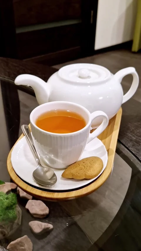 White Ceramic Teapot and Cup of Hot Tea with Biscuit on Wooden Tray Stock Footage 339003796