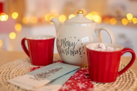 White Ceramic TeaPot with text Merry Christmas and cups with marshmallows on Stock Photos
