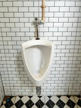 White Ceramic Urinal in Public Restroom with Subway Tiles Stock Photos
