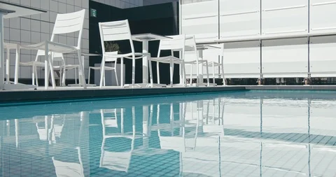 White chair and table is next to the blue water pool. Vacation concept. Stock Footage 120430168