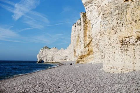 White chalk cliffs and pebble beach on a sunny day in Etretat, Normandy, Fran Stock Photos
