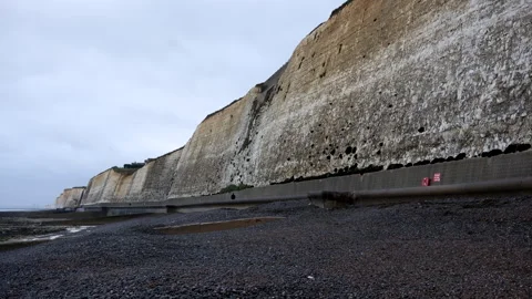 White Chalk Cliffs and Shingle Beach Under Overcast Sky Stock Footage 328159424