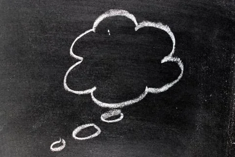 White chalk hand drawing in cloud bubble speech shape with blank space on bla Stock Photos