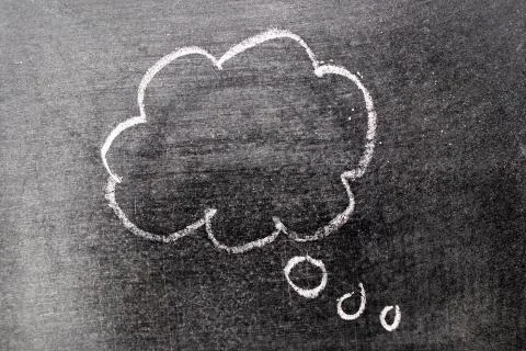 White chalk hand drawing in cloud bubble speech shape with blank space on bla Stock Photos