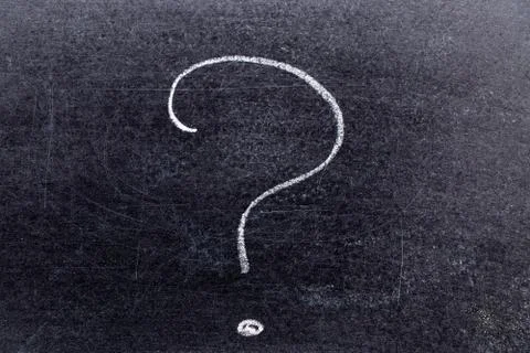 White chalk hand drawing in question mark shape on black board background Stock Photos
