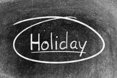 White chalk hand writing in word holiday and circle shape on blackboard bac.. Stock Photos
