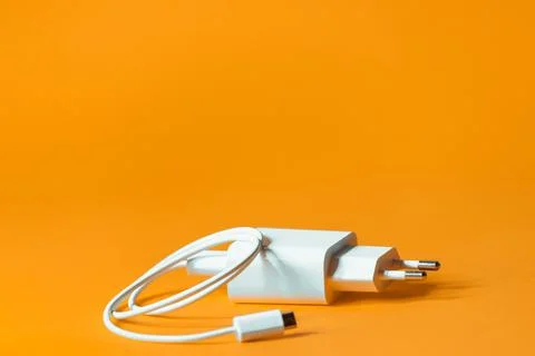 White charger with micro usb on a bright yellow background. Stock Photos