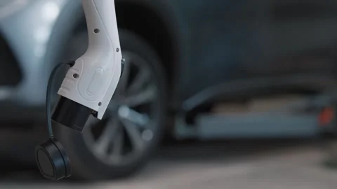 White charging cable hooks into electric car's port 库存影片 339546487