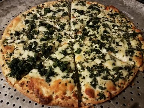 White cheese and spinach pizza on metal baking tray Stock Photos