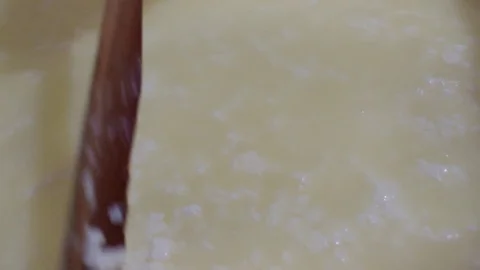 White cheese making process, wooden spoon mixing cheese curd Stock Footage 81527801