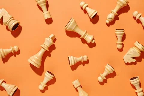 White chess pieces pattern on an orange background. Stock Photos