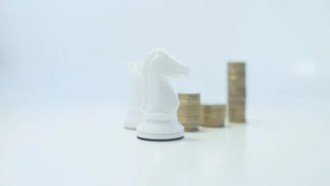 White chess pieces on a white background. Golden stack of metallic coins. Stock Footage 346205387