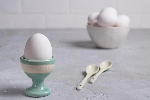 White  chicken  egg in ceramic stand and eggs in white  bowl . Foto stock