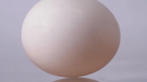 White chicken egg spinning on a white background or white table. Nutrition 스톡 동영상 150560341