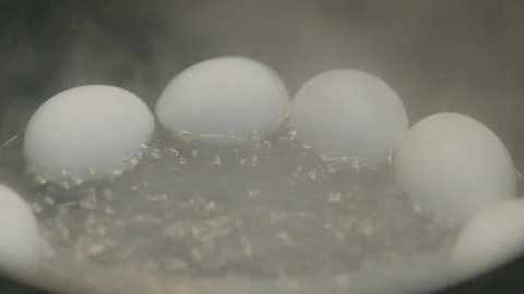 White chicken eggs boiling in hot water pot Stock Footage 337615152