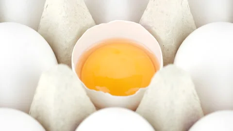 White chicken eggs. Broken egg and whole eggs in box, rotation Stock Footage 202300679