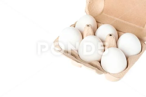 White chicken eggs in carton box isolated on white background Stock Photos
