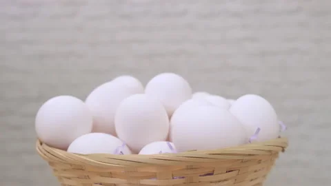 White chicken eggs rotate in basket on light background Video stock 171225091