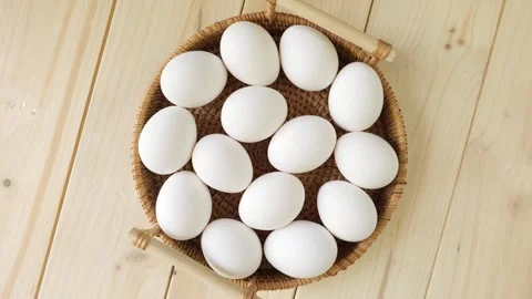 White chicken eggs spinning in a wicker basket Stock Footage 335560034