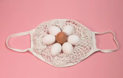 White chicken eggs in a string bag, on a pink background Stock Photos